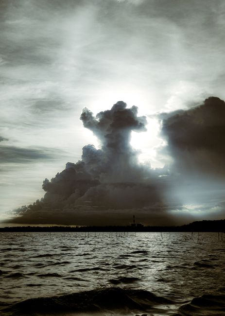 A stunning cloud formation over a serene lake captures the essence of a dramatic sunset.