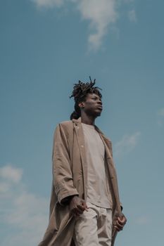 Tall Man in Long Coat with Sky Background