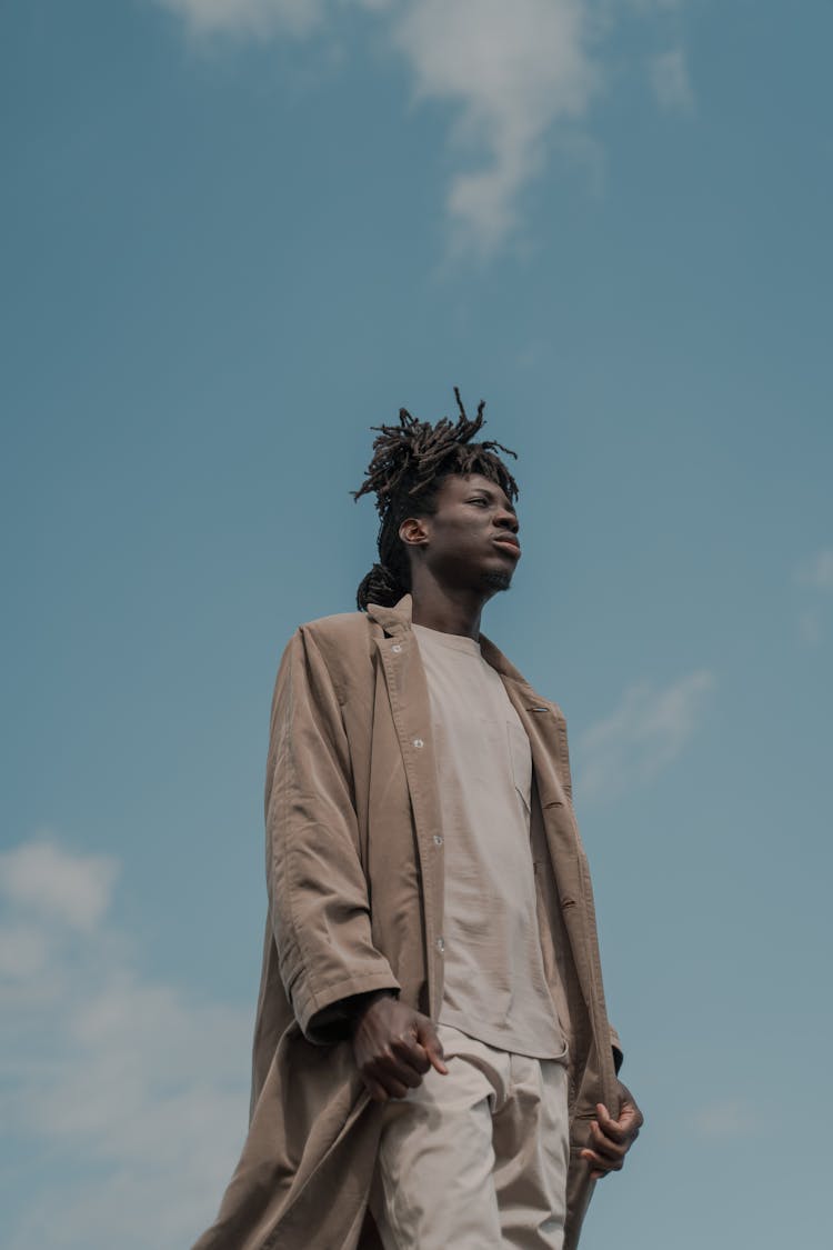 Tall Man In Long Coat With Sky Background