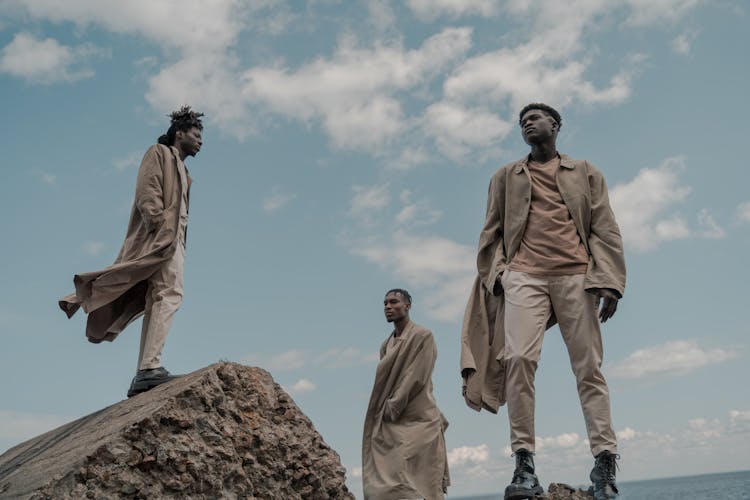 Three Men Standing On Rocks