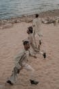 Three Men Spending Time on Outdoor Activity on Beach Shore