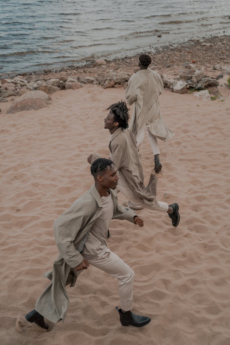 Three Men Spending Time On Outdoor Activity On Beach Shore