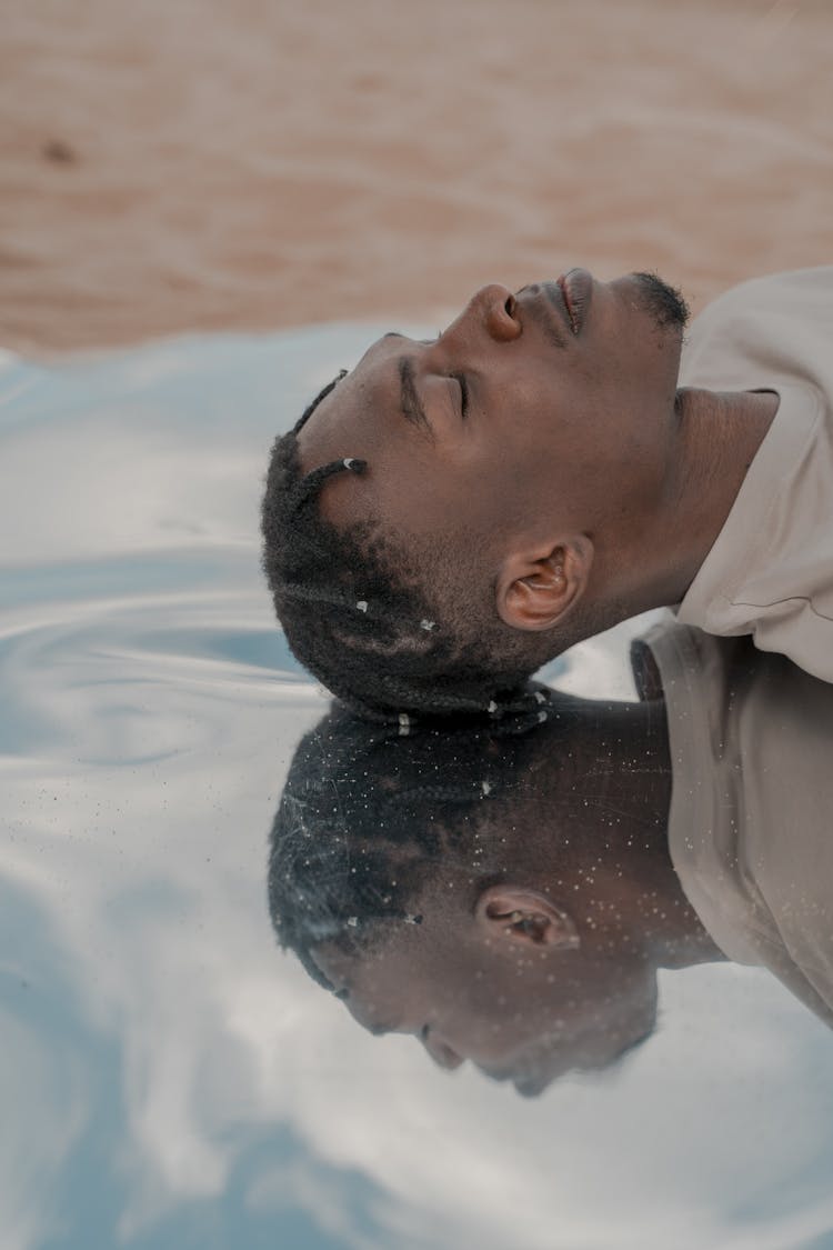 Portrait Of Man Laying With Head Touching Water