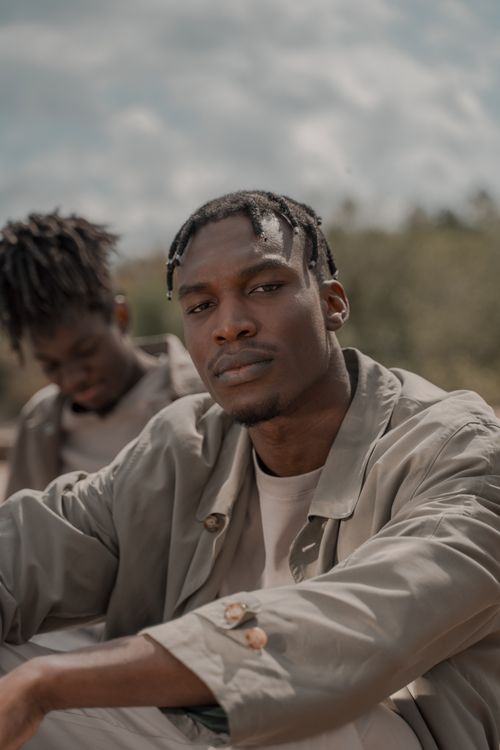 Free Close-up of a young man with braided hair outdoors, exuding a contemplative mood. Stock Photo