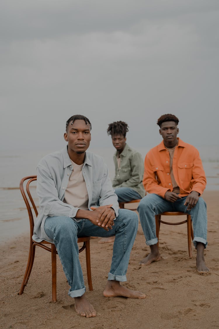 Men In Long Sleeves Sitting On Chairs At The Beach