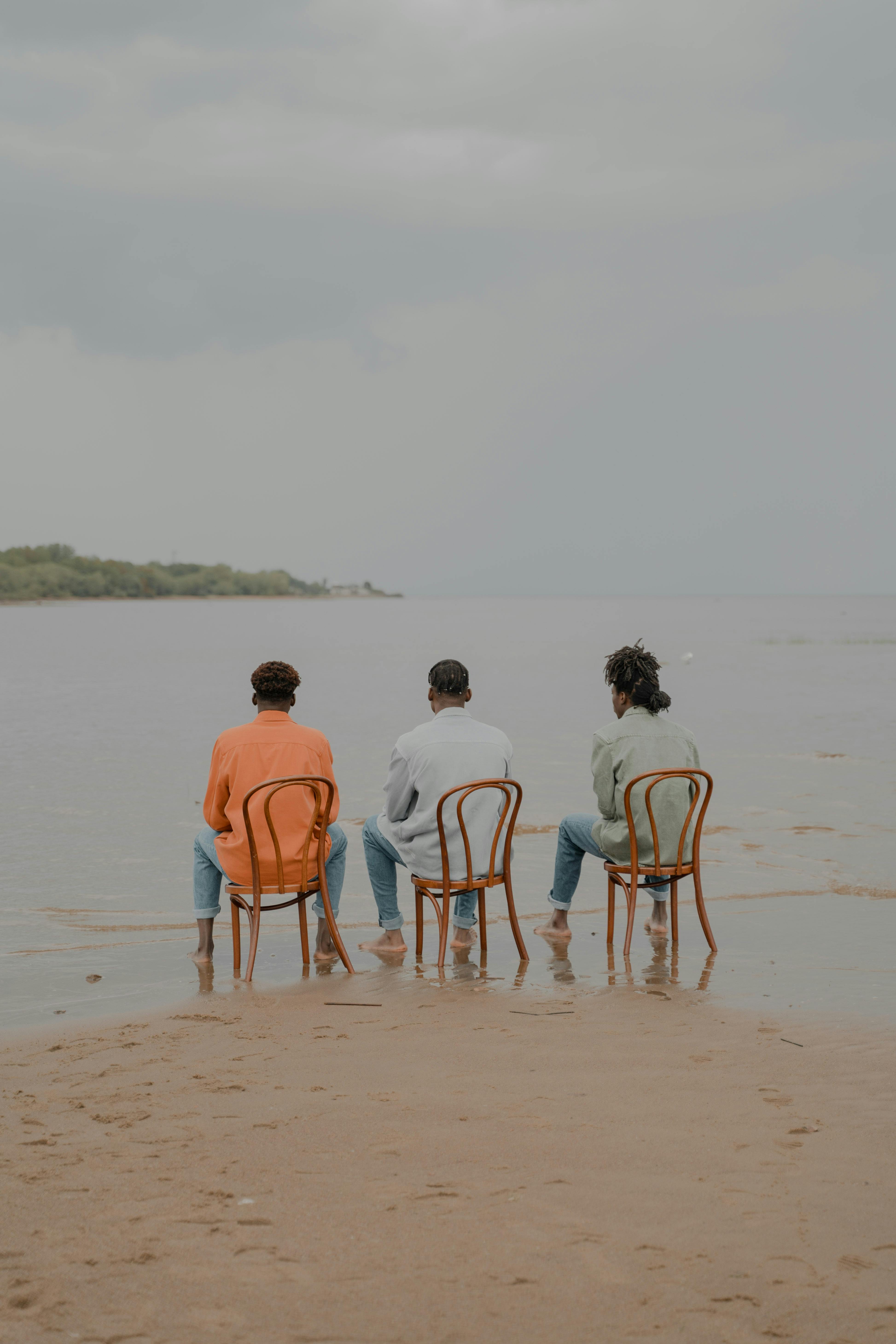 Three Men Sitting on Chairs Under Water · Free Stock Photo