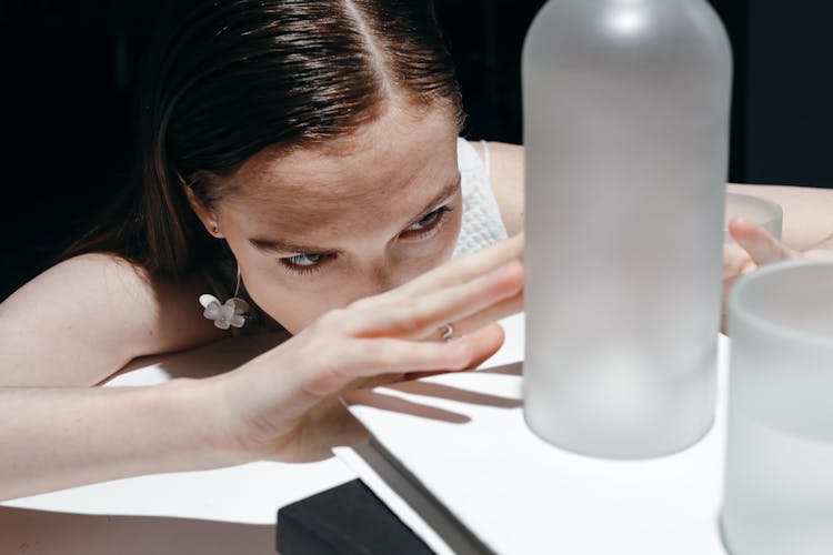 Woman Looking At The Glass Bottle