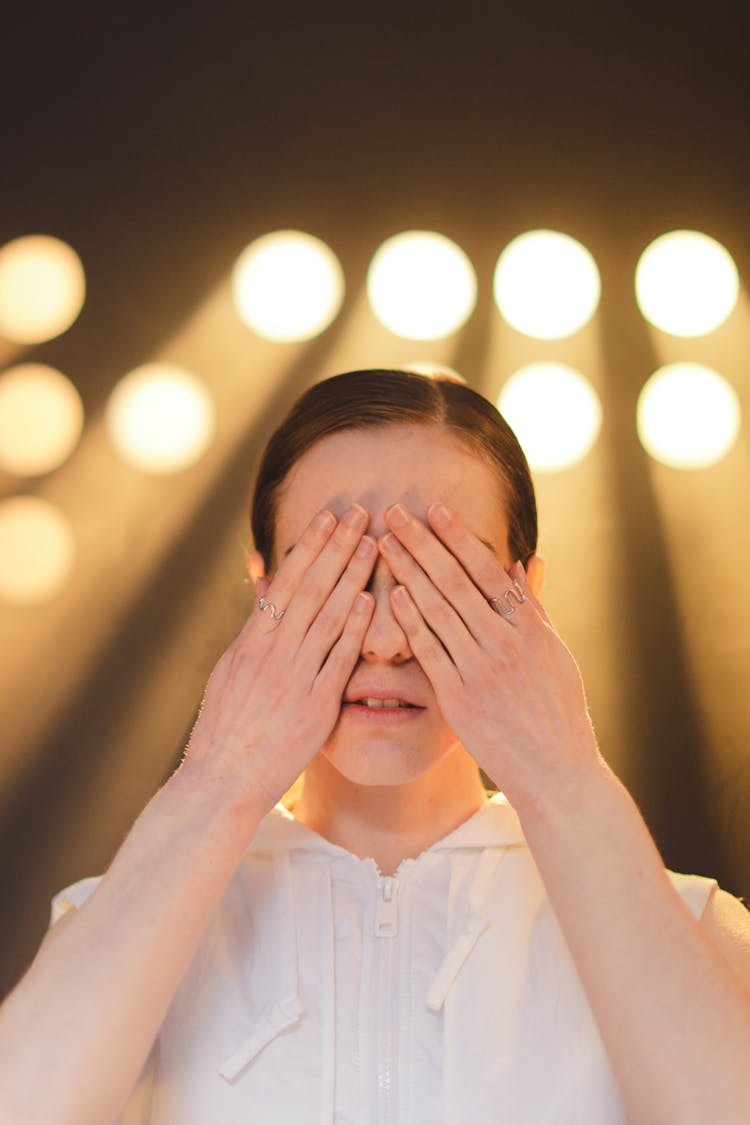 A Woman Covering Her Eyes Using Her Hands