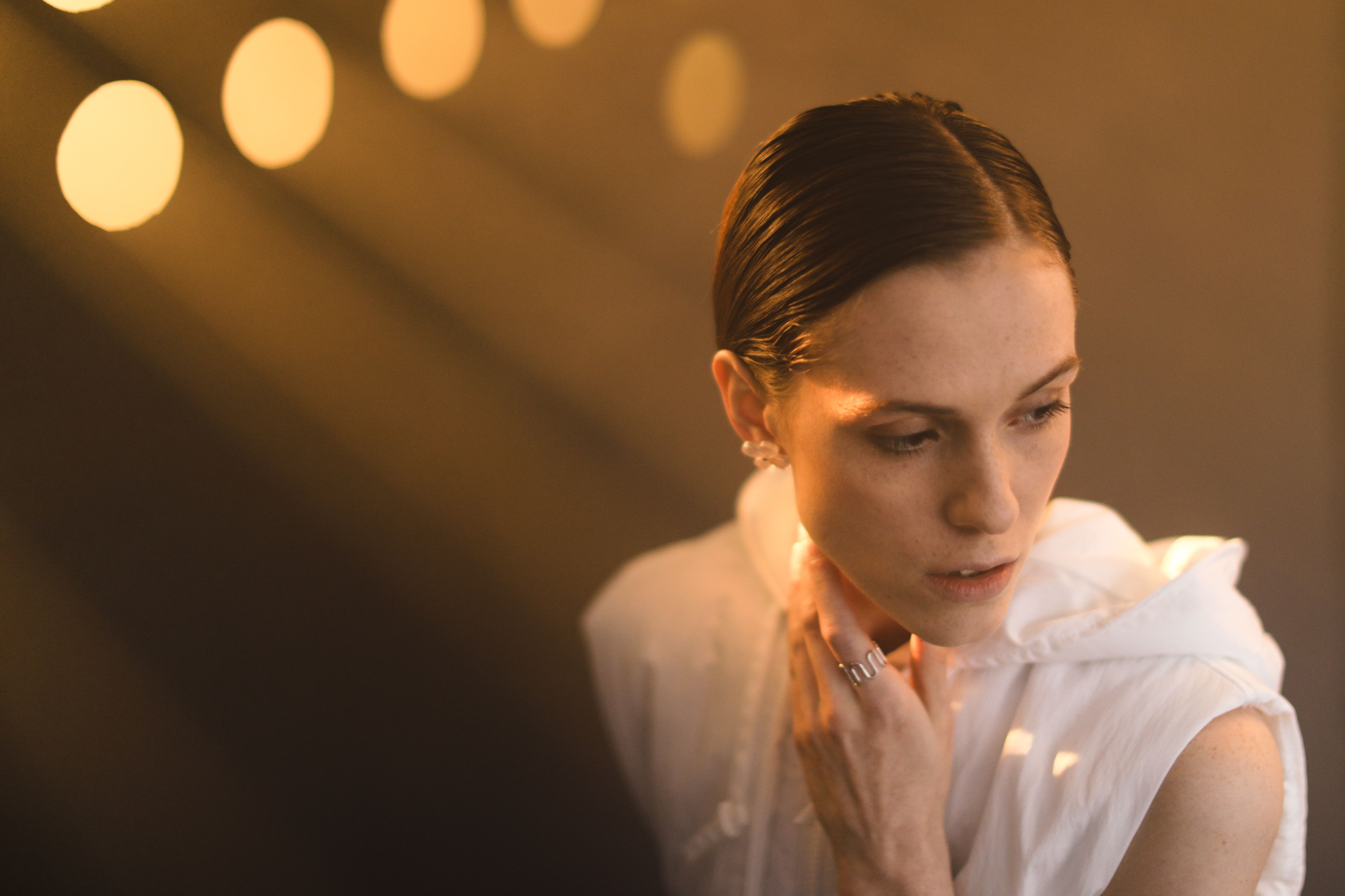 A Woman Touching Her Neck while Looking Afar · Free Stock Photo