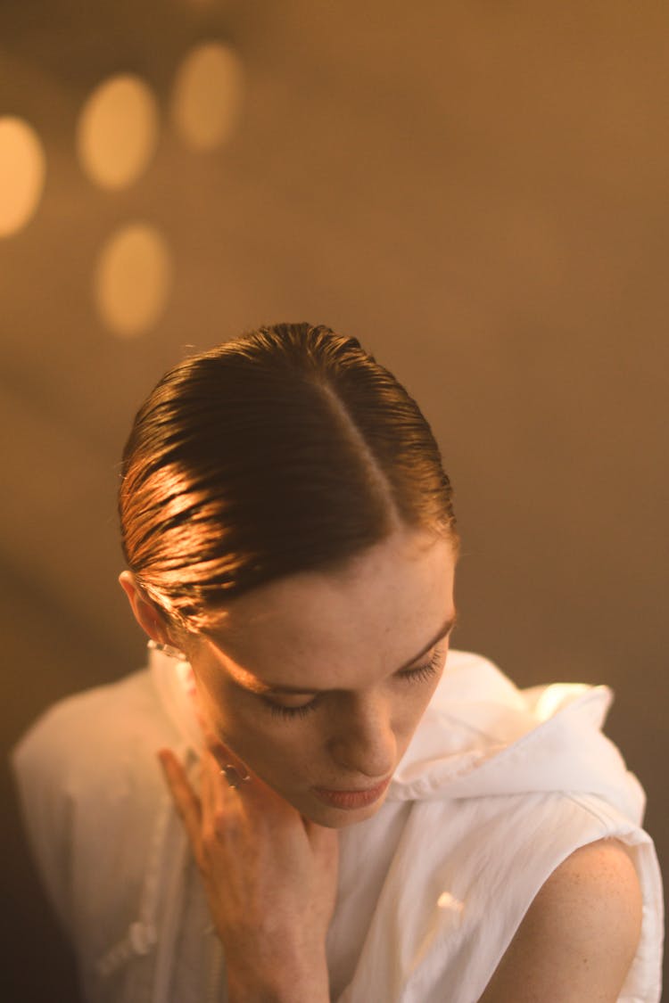 Woman Touching Her Neck While Looking Down