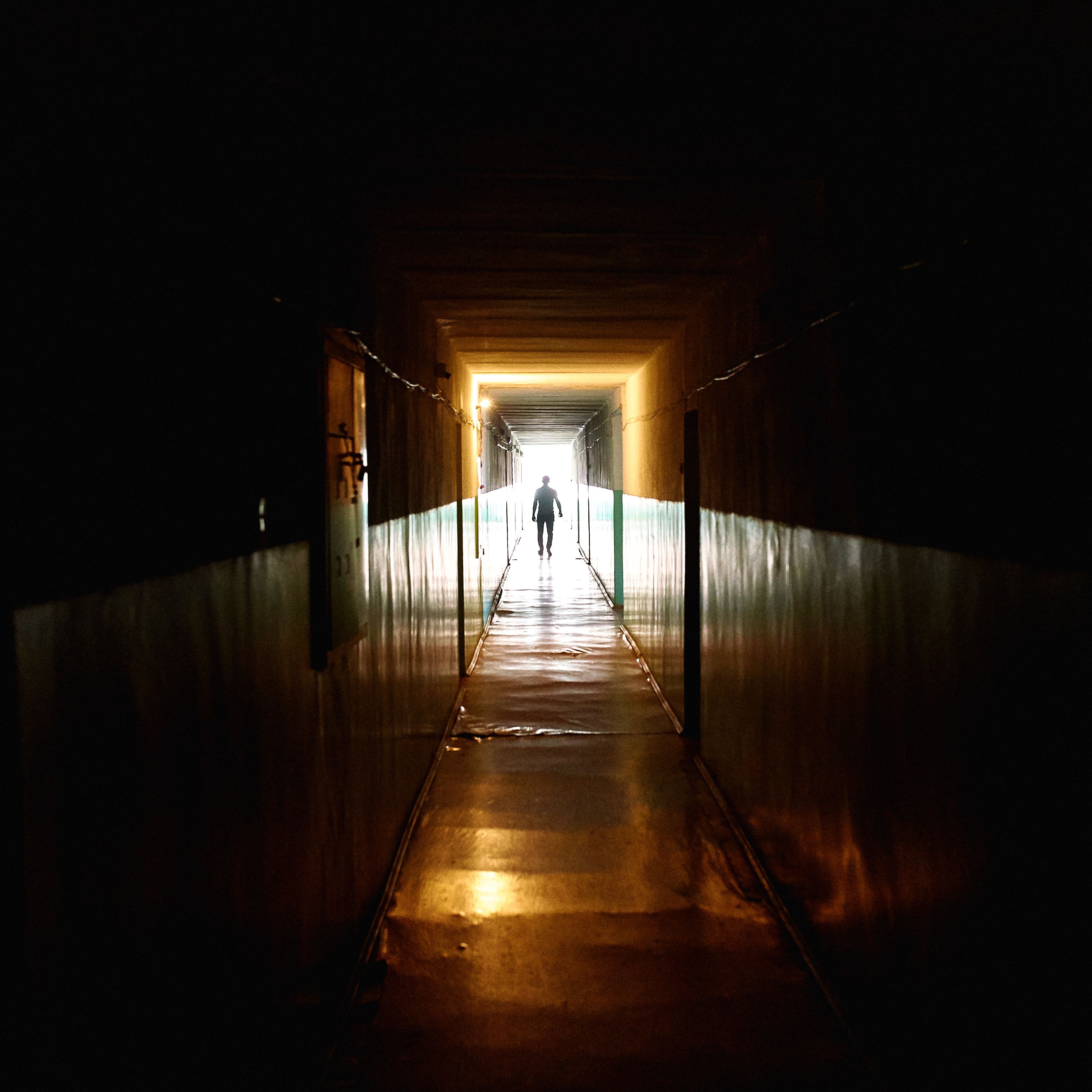 A Silhouette of a Person Walking on Internal Corridor&nbsp;
