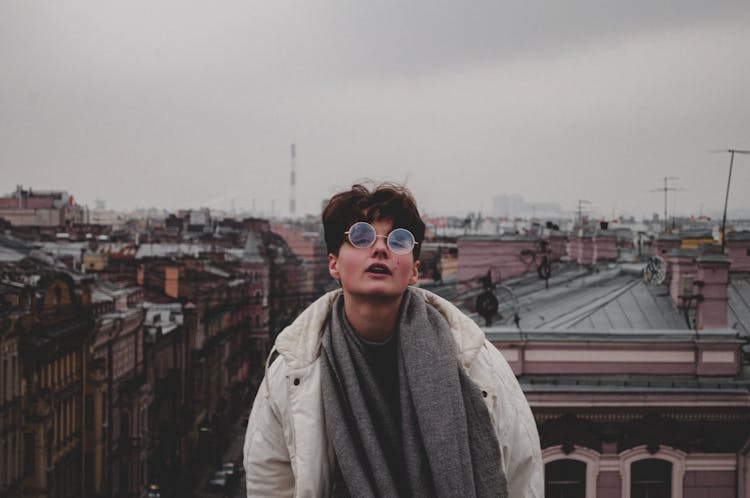 Photo Of A Woman Wearing Round Eyeglasses And City Roofs In Background