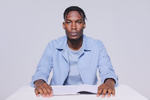 A Man Sitting on a Chair while Seriously Looking at the Camera