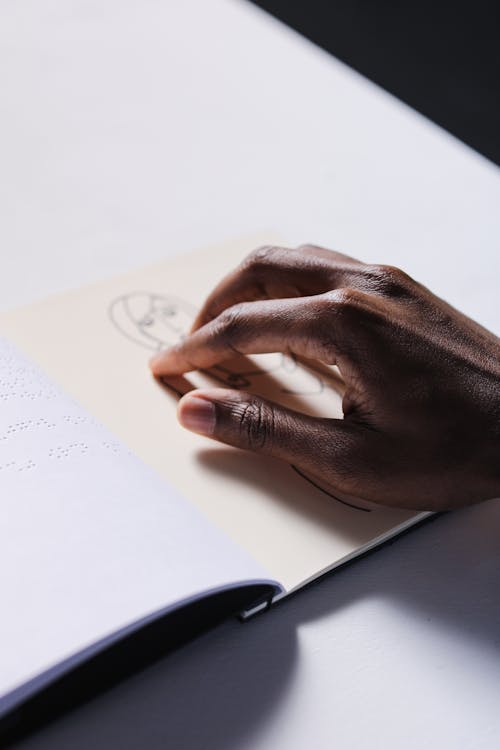 Free A Person Touching a Drawing on White Paper Stock Photo