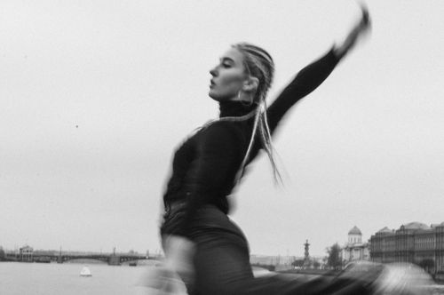 Free Captivating black and white image of a woman dancing energetically by the riverside. Stock Photo