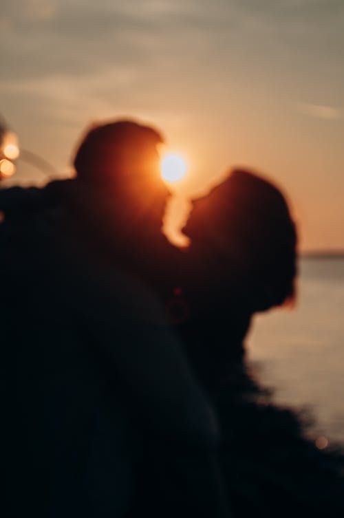 Free Silhouette of Couple Looking at Each Other during Golden Hour Stock Photo