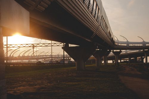 Free A sleek train glides on elevated tracks at sunset, highlighting modern transportation. Stock Photo