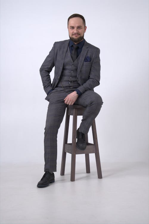 Free Man in Gray Suit Sitting on Brown Wooden Seat Stock Photo