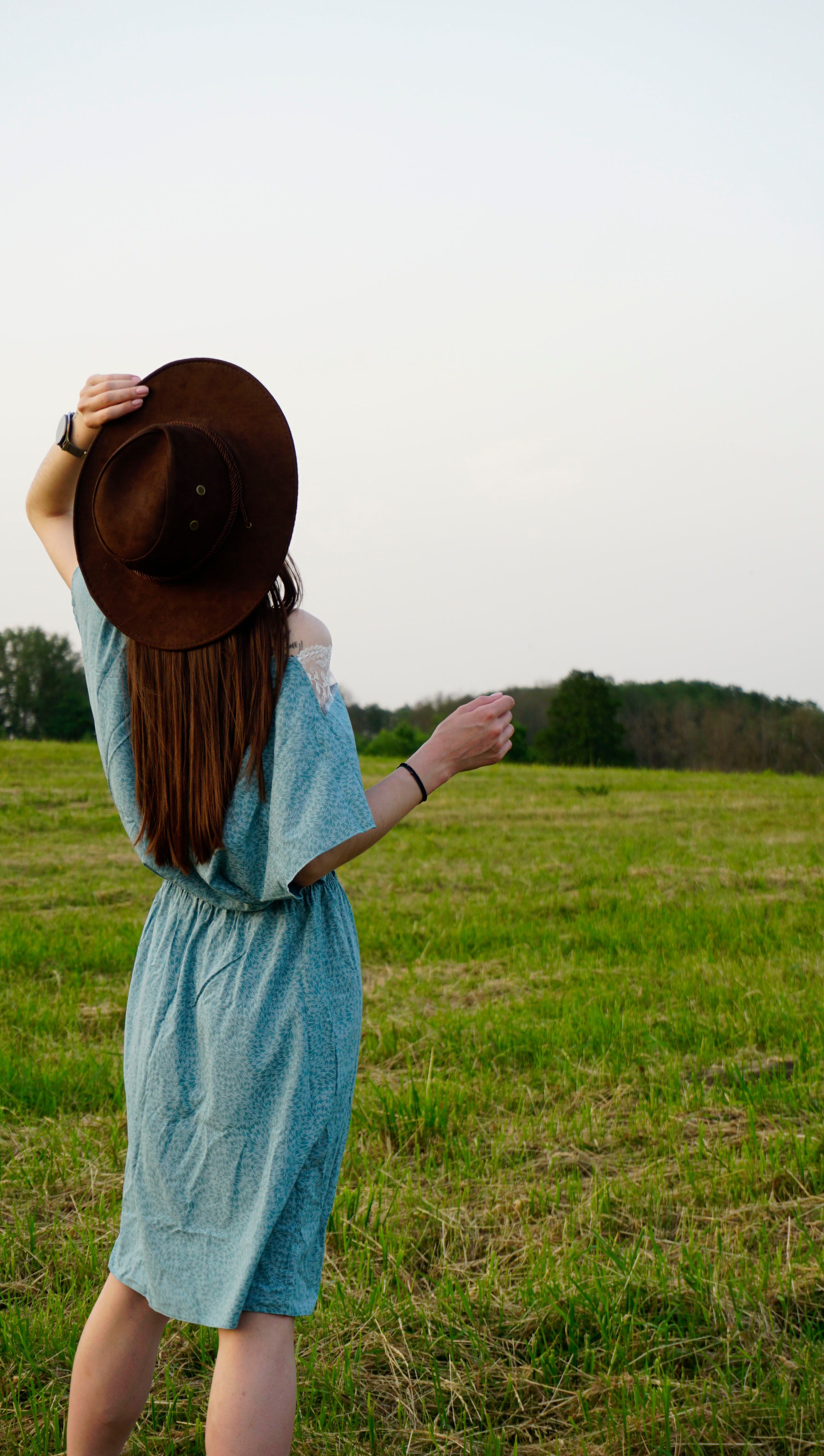A Woman in a Blue Dress Running on a Grassy Field · Free Stock Photo