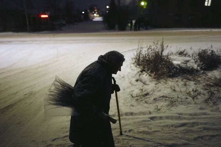 A Side View Of Silhouette Of Elderly Female In Winter 