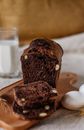 A Shot of Dark Bread on Cutting Board With Glass of Milk in Background 