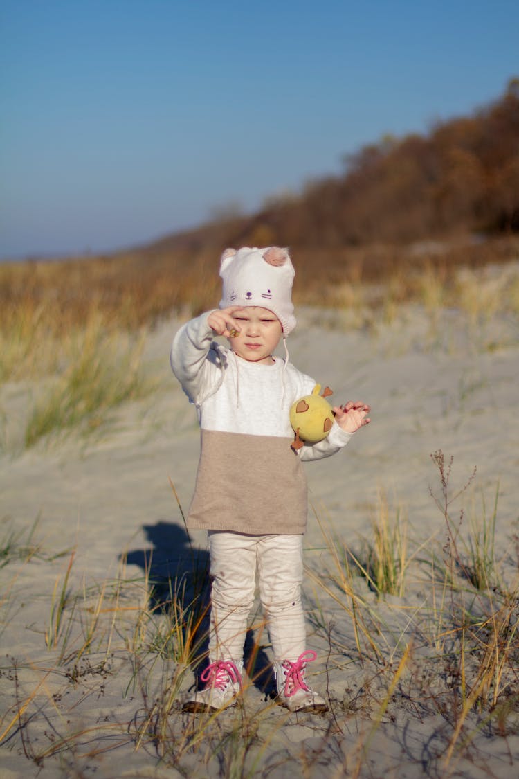 A Child Standing On A Beach