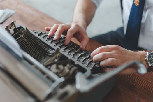 A detailed close-up of hands working on a classic vintage typewriter, capturing the essence of traditional writing.