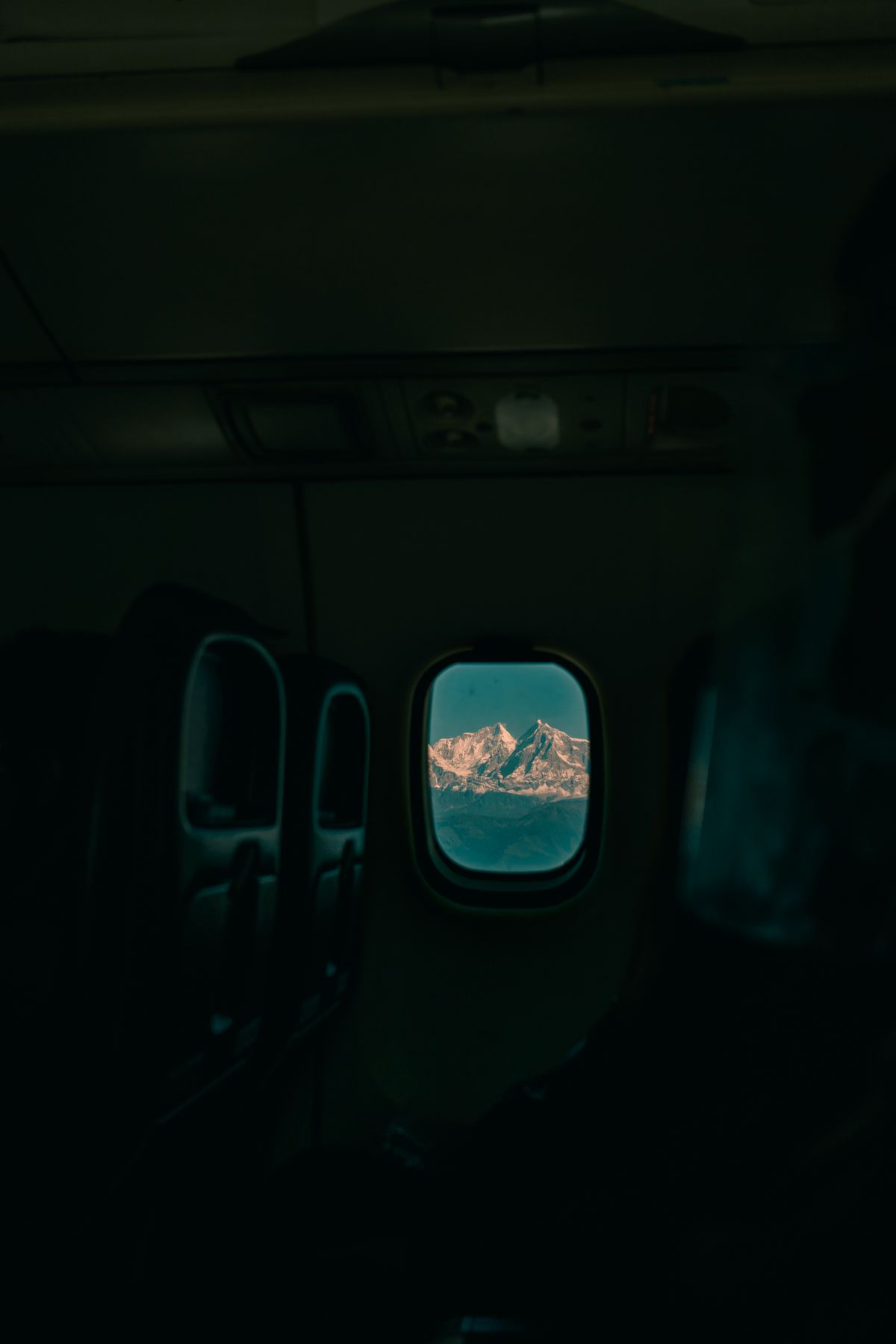 Snow-covered mountains seen through an airplane window