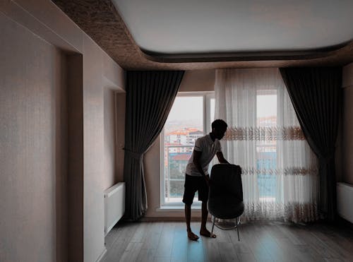 Man Moving the Chair Inside the Room
