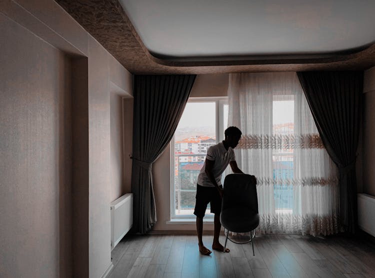 Man Moving The Chair Inside The Room