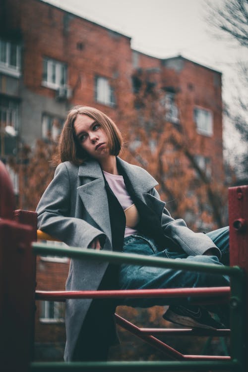 Woman Wearing Gray Coat Sitting Looking Away