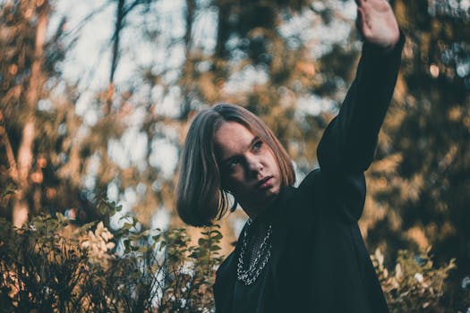 Portrait of a young woman posing outdoors with an autumnal blurred background.