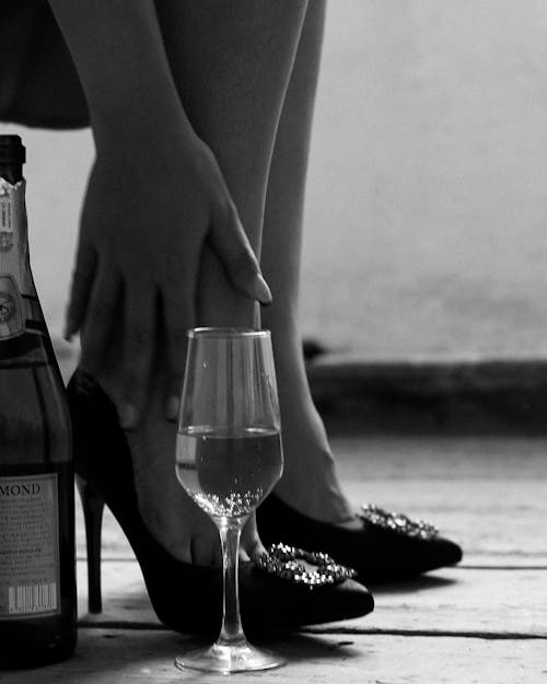 Free Person in High Heels Sitting with Glass of Wine on Floor Stock Photo