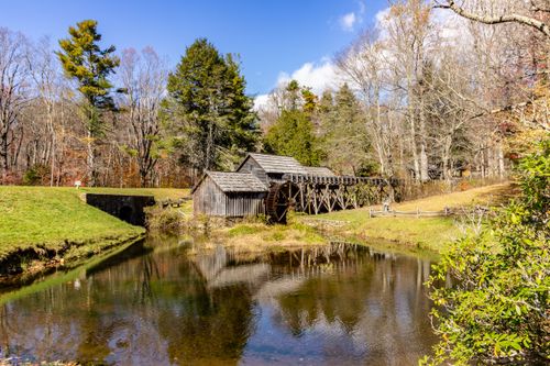 Free Picturesque view of Mabry Mill reflecting in a pond surrounded by fall foliage in Meadows of Dan, Virginia. Stock Photo