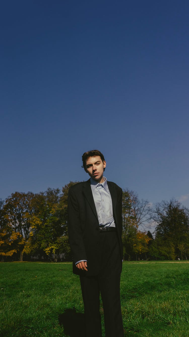 Portrait Of Man In Full Suit Standing On Grass