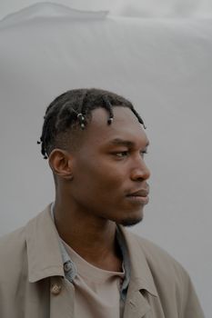 Side profile of a man with braided hair against a white background.