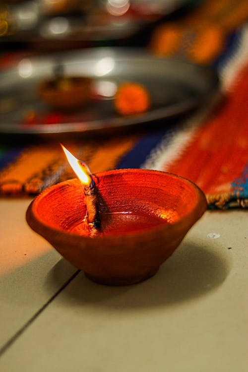 Lighted Candle in Red Ceramic Bowl