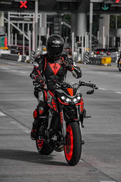 Free Man Riding a Black and Orange Motorcycle Stock Photo
