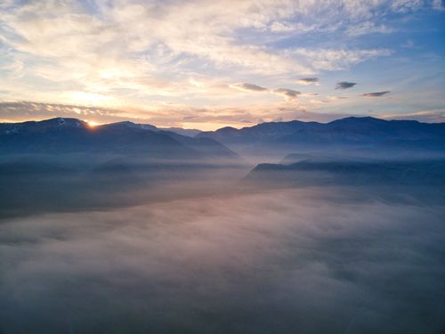 Free Serene mountain landscape at sunrise with fog-filled valleys and a vibrant sky. Stock Photo