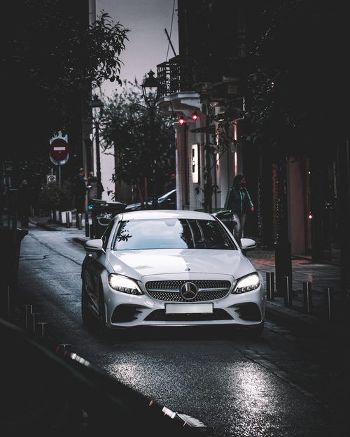 Free Elegant Mercedes cruising through a rainy street in Thessaloniki, Greece, showcasing automotive luxury. Stock Photo
