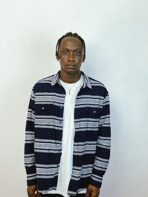 Man in Blue and White Striped Long Sleeves Shirt Seriously Looking at the Camera