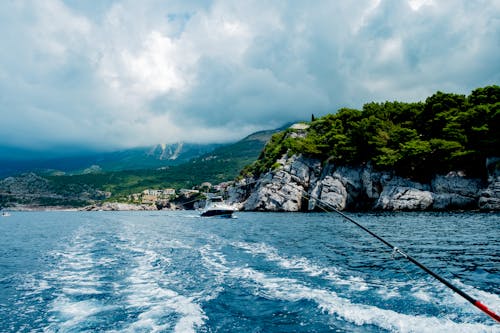 Rocky Mountain Beside Body of Water Under a Cloudy Sky