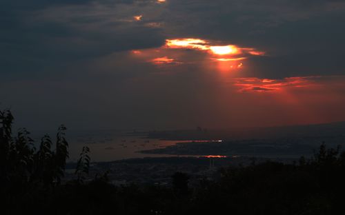 Free Stunning sunset over coastline with vibrant sky and dramatic clouds. Stock Photo
