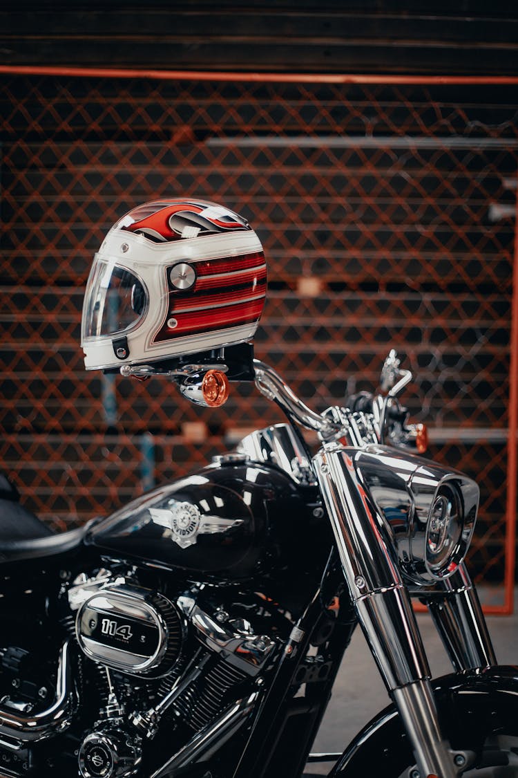 White And Red Helmet On Top Of Motorcycle