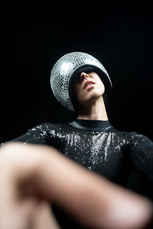 Portrait of Woman with Disco Ball Hat Reaching Towards Camera