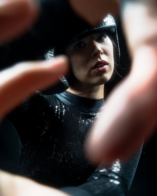 Young Woman in Silver Shining Helmet Behind Somebodys Fingers