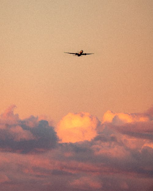 An Airplane Flying in the Sky during Sunset