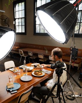 Photographer capturing food in a studio with professional lighting.