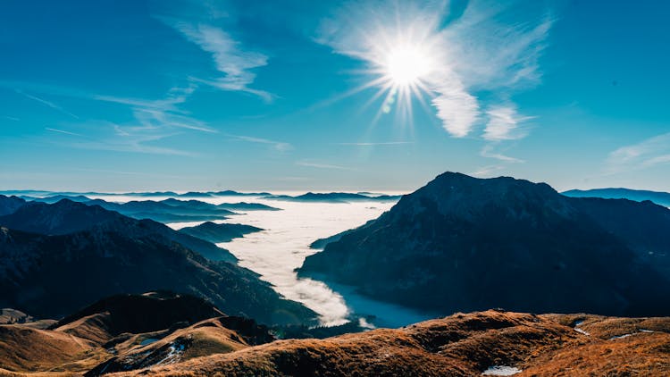 Rocky Mountains In Fog And Sun In Blue Sky