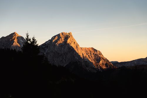 Free Stunning sunset lighting up rugged mountain peaks, creating a dramatic landscape view. Stock Photo